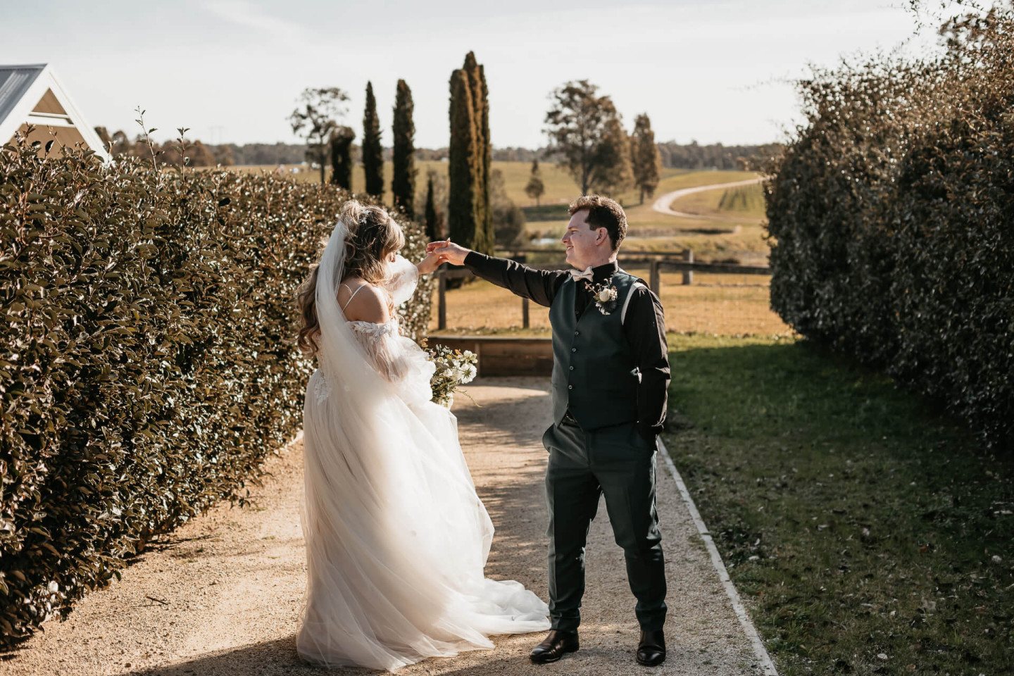 A couple walking between the cypress hedges